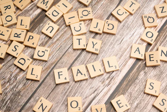 Scrabble tiles on wood form 'FAIL', symbolizing defeat and reflection. Workflow error handling